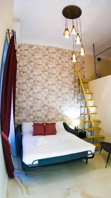 a bedroom with a bed and a wall with a staircase at RESIDENZA ROSA in Rome