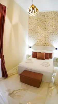 a bedroom with a white bed and a chandelier at RESIDENZA ROSA in Rome