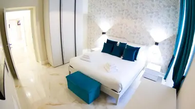 a bedroom with a white bed with blue pillows at RESIDENZA ROSA in Rome
