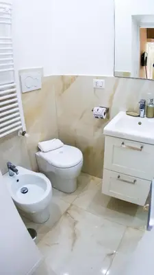 a white bathroom with a toilet and a sink at RESIDENZA ROSA in Rome