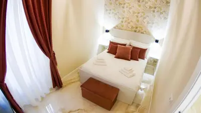 a small bedroom with a white bed with brown pillows at RESIDENZA ROSA in Rome