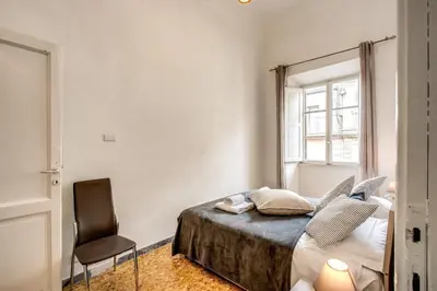 a bedroom with a bed and a chair and a window at Suite Experience Termini Station Apartment in Rome
