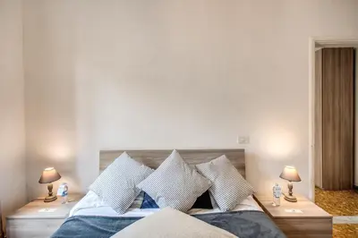 a bedroom with a bed with blue and white pillows at Suite Experience Termini Station Apartment in Rome