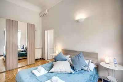 a large blue bed in a room with a mirror at Suite Experience Termini Station Apartment in Rome