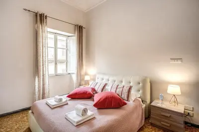 a bedroom with a bed with red pillows and a window at Suite Experience Termini Station Apartment in Rome