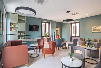 a waiting room with tables and chairs and a library at HOTEL DELLE CIVETTE in Rome