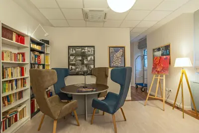 a library with a table and chairs and bookshelves at HOTEL DELLE CIVETTE in Rome