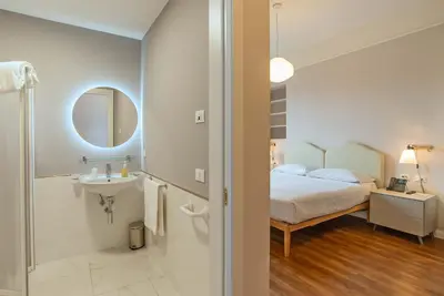 a bedroom with a bed and a sink and a mirror at HOTEL DELLE CIVETTE in Rome