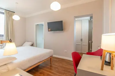a bedroom with a bed and a tv on the wall at HOTEL DELLE CIVETTE in Rome