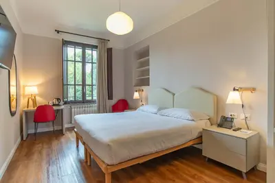 a bedroom with a large bed and two red chairs at HOTEL DELLE CIVETTE in Rome