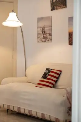 a white couch with an american flag pillow on it at Domus Antonia in Rome