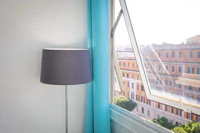 a lamp in a room with a large window at Laterano View by Rental in Rome in Rome