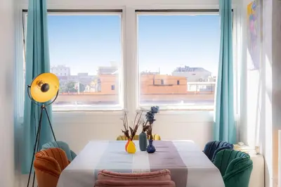 a room with a table and two large windows at Laterano View by Rental in Rome in Rome
