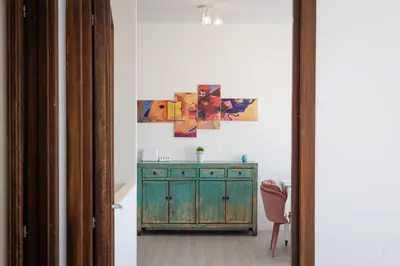 a room with a green dresser and paintings on the wall at Laterano View by Rental in Rome in Rome
