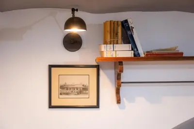 a shelf with books and a clock on a wall at Pantheon by Rental in Rome in Rome