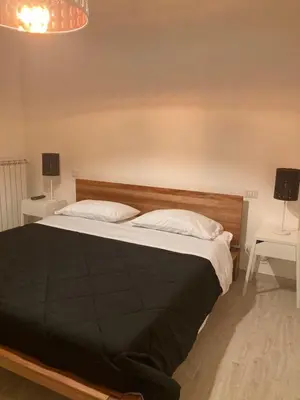 a bedroom with a bed with two tables and two lamps at 8380 Lory's House in Rome