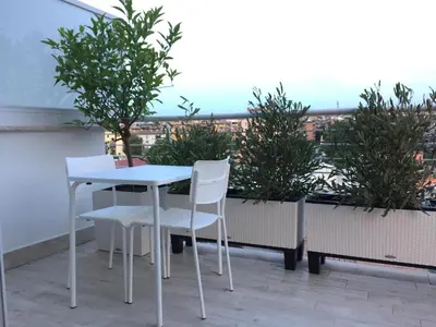 a white table and chairs on a balcony with plants at 8380 Lory's House in Rome