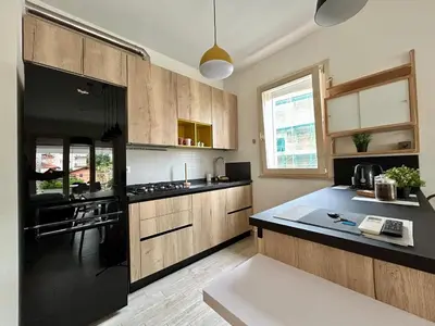 a kitchen with a black refrigerator and wooden cabinets at 8380 Lory's House in Rome