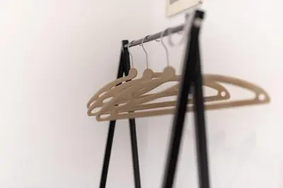 a wooden hanger on a white wall with black poles at Evelina in Trastevere in Rome