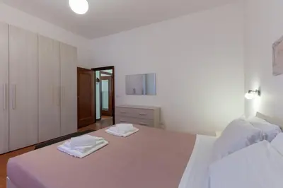 a white bedroom with a large bed with towels on it at Evelina in Trastevere in Rome