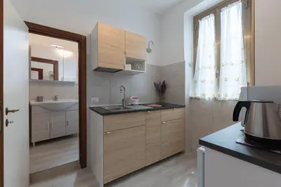 a kitchen with wooden cabinets and a sink and a mirror at Evelina in Trastevere in Rome