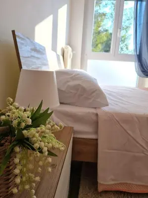 a bedroom with a bed and a table with flowers on it at Casa del Vicario al Vaticano in Rome