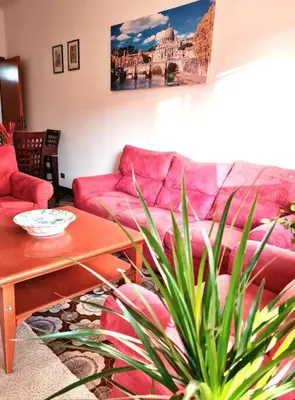 a living room with a pink couch and a table at Casa del Vicario al Vaticano in Rome