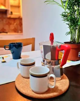 a coffee maker and two cups on a table at Casa del Vicario al Vaticano in Rome