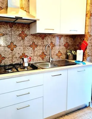 a kitchen with white cabinets and a sink at Casa del Vicario al Vaticano in Rome
