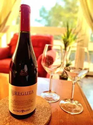 a bottle of wine sitting on a table with two glasses at Casa del Vicario al Vaticano in Rome
