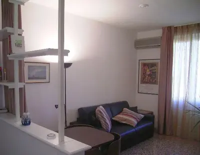 a living room with a blue couch and a table at Cathy Apartment in Rome