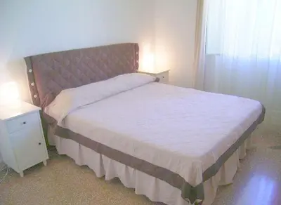 a bedroom with a bed and a nightstand with a white bedspread at Cathy Apartment in Rome