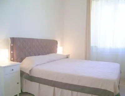 a bedroom with a bed with a headboard and a window at Cathy Apartment in Rome