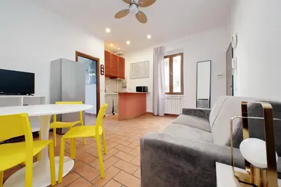 a living room with a couch and a table and yellow chairs at Homs Apartment In Rome by Halldis in Rome