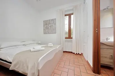 a white bedroom with a bed and a sink at Homs Apartment In Rome by Halldis in Rome
