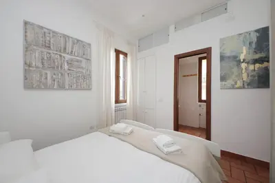 a white bedroom with a bed with two towels on it at Homs Apartment In Rome by Halldis in Rome
