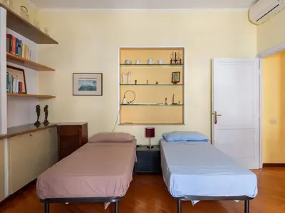 a room with two beds and a shelf at Porta Pia Elegant Two Bedroom in Rome