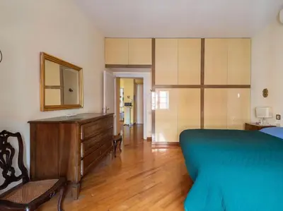 a bedroom with a bed and a dresser and a mirror at Porta Pia Elegant Two Bedroom in Rome