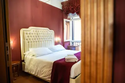 a bedroom with a white bed with a red wall at Imperial GuestHouse in Rome