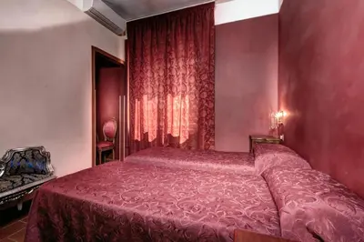 a bedroom with a bed in a red room at Imperial GuestHouse in Rome