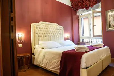 a bedroom with a white bed with a red wall at Imperial GuestHouse in Rome