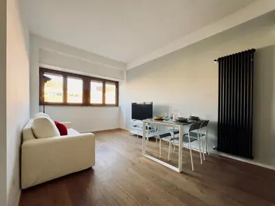 a living room with a couch and a table with a chair at The Twenty - Villaggio Olimpico apartment in Rome