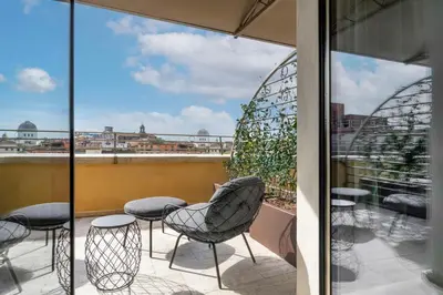 a balcony with chairs and a view of a city at Radisson Collection Hotel, Roma Antica in Rome