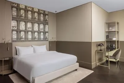 a bedroom with a large white bed and a desk at Radisson Collection Hotel, Roma Antica in Rome
