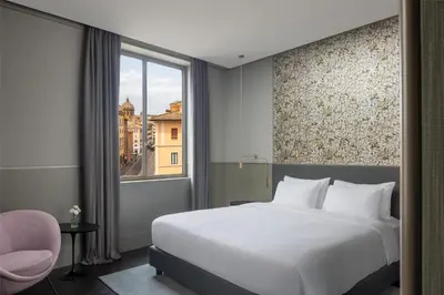 a bedroom with a large white bed and a window at Radisson Collection Hotel, Roma Antica in Rome
