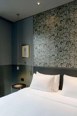a bedroom with a white bed and a wall at Radisson Collection Hotel, Roma Antica in Rome