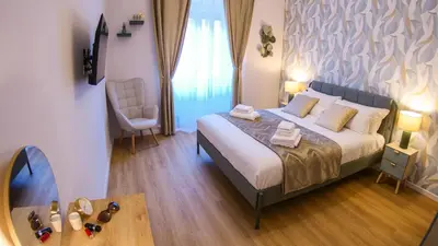 a bedroom with a bed and a table and a chair at Baronio Apartment in Rome