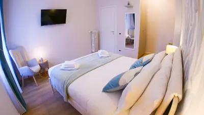 a bedroom with a large white bed in a room at Baronio Apartment in Rome