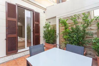 a white table and chairs on a balcony with plants at Vatican Vittoria Suites - Vatican museums in Rome
