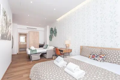 a bedroom with two beds and a living room at Vatican Vittoria Suites - Vatican museums in Rome